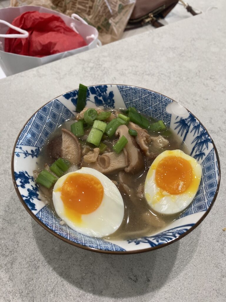 Mushroom miso soup with egg in a blue and white bowl