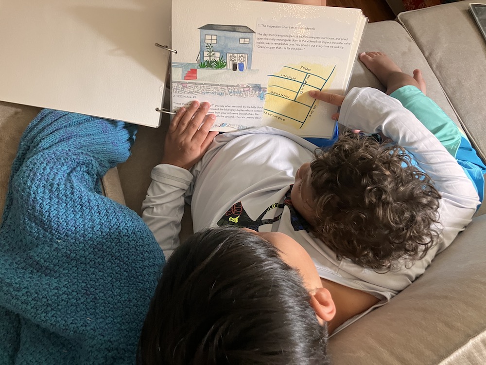 A 9-year-old reads a book with his 2-year-old brother